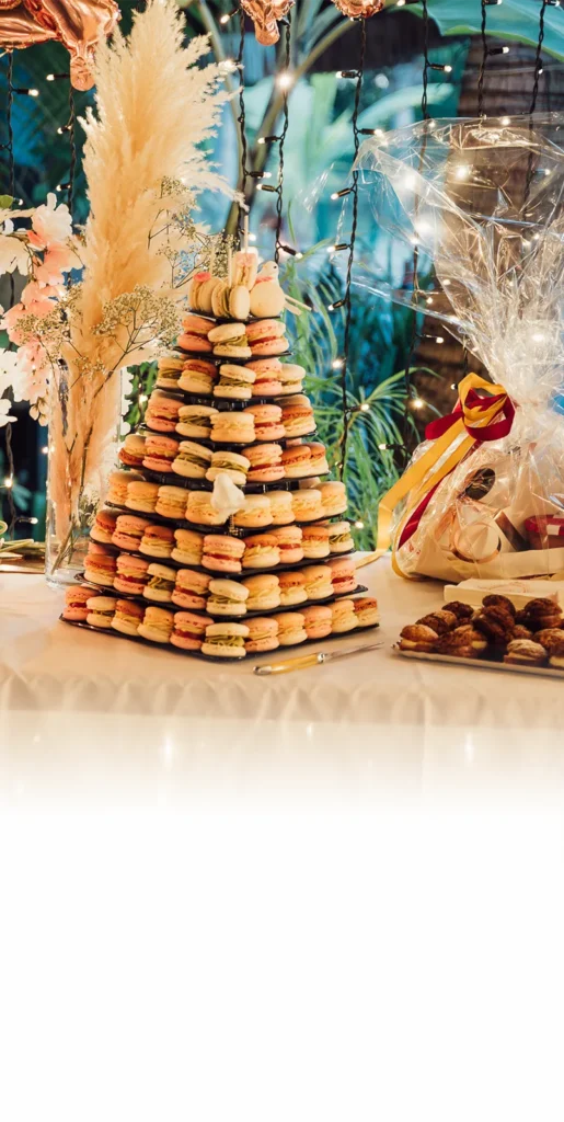 Table de mariage avec une pyramide de macarons aux couleurs pastel